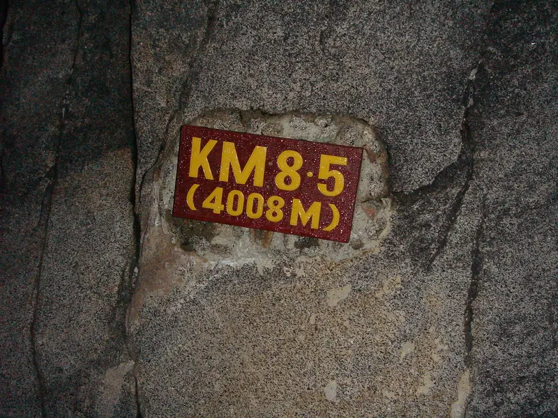 Le panneau « KM 8.5 (4 008 m) » sur la roche