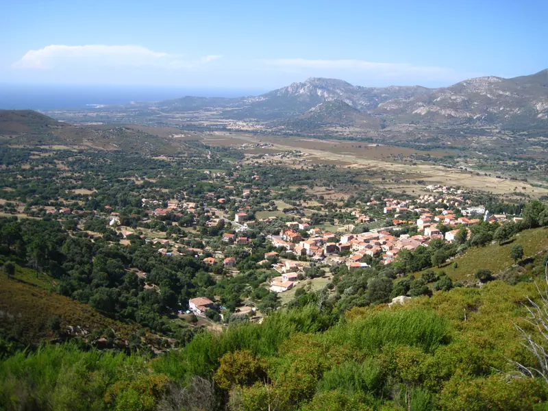 Un village dans la plaine, la mer au fond