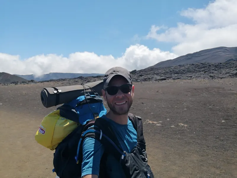 Sam en randonnée : sac au dos sur un plateau volcanique
