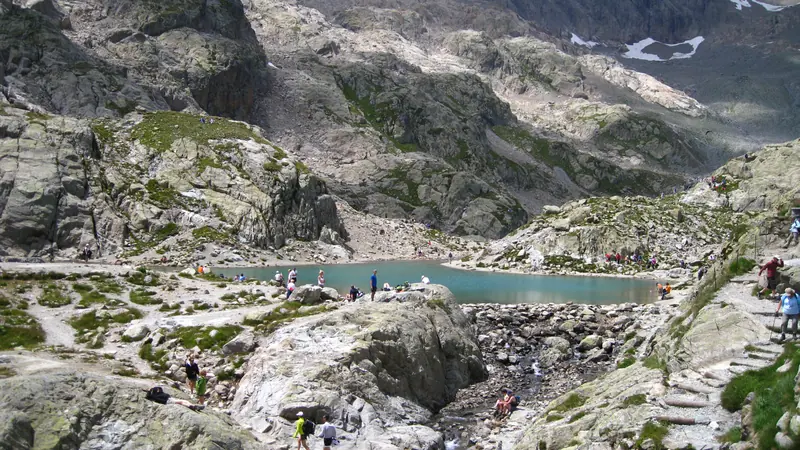 Un lac au creux des rochers, des promeneurs sur la rive