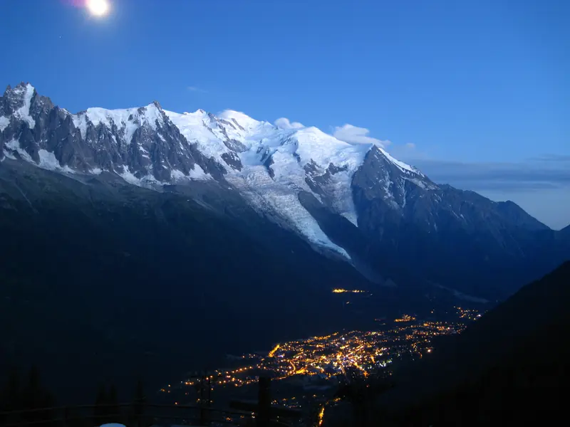 La vallée illuminée la nuit, au pied du massif